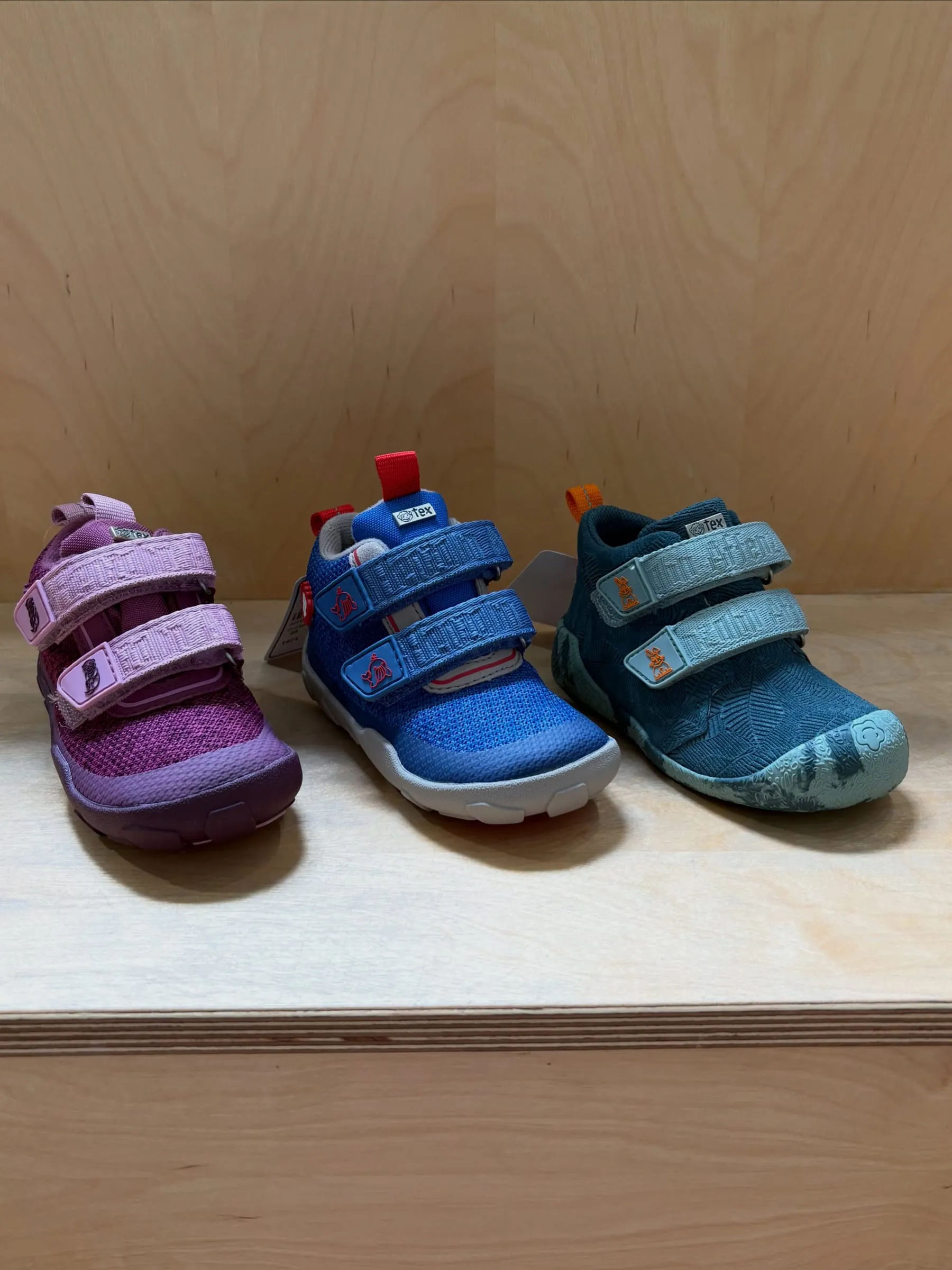 Drei farbige flexible Kinderschuhe für die ersten Schritte