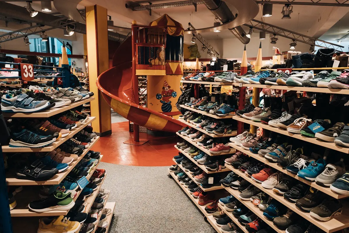 Kinderschuhabteilung mit Schuhregalen und Rutsche bei Heinmüller