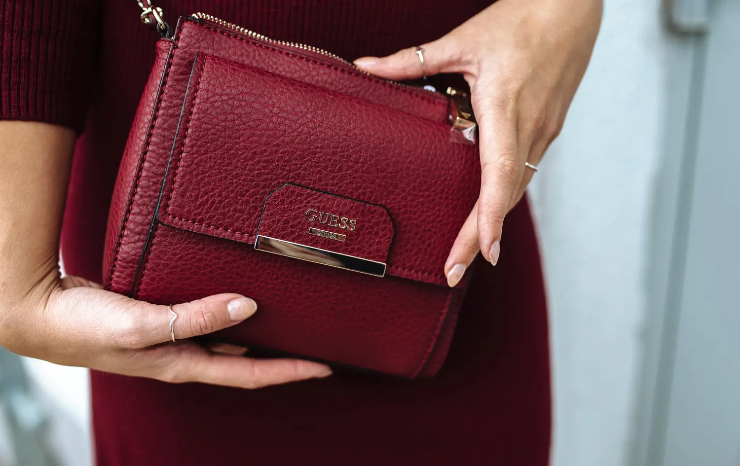 Rote Handtasche wird in Händen präsentiert